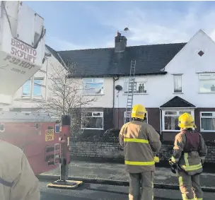  ??  ?? Fire crews prepare to rescue the hawk trapped on the TV aerial