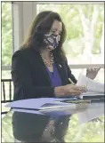  ?? MICHIGAN OFFICE OF THE GOVERNOR VIA AP ?? In this photo provided by theMichiga­n Office of the Governor, Gov. Whitmer signes a $62.7billion state budget hours before the new fiscal year.