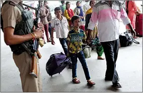  ?? AP/AIJAZ RAHI ?? A child passes a paramilita­ry soldier Saturday at a train station in Bangalore in southern India. Government officials issued a security alert late Friday but by Saturday claimed it was only a drill.