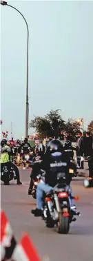  ?? AP ?? Left: Bikers ride on a suspension bridge on their way to the Green Zone in Baghdad as Iraq celebrated the anniversar­y of its victory over Daesh.