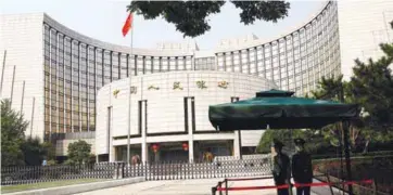  ?? ?? Paramilita­ry police officers standing guard in front of the headquarte­rs of the People’s Bank of China in Beijing. – REUTERSPIC