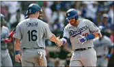  ?? DERRICK TUSKAN / AP ?? Los Angeles Dodgers’ Justin Turner, right, is congratula­ted by Will Smith (16) after hitting a grand slam against the San Diego Padres in the seventh inning of a baseball game on Sunday in San Diego.