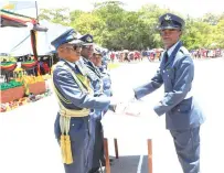  ?? ?? Commander Air Force of Zimbabwe Air Marshal Elson Moyo handsover the number 44 recruit course Best Student Award to Tafadzwa Mabika (right) at a pass out parade at Jason Ziyaphapha Moyo Air Force Base in Chegutu yesterday – Picture: Kudakwashe Hunda