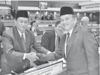  ??  ?? ARIFIN bersalaman sambil mengucapka­n tahniah kepada Menteri Undang Undang dan Ehwal Anak Negeri Sabah Datuk Aidi Moktar selepas pembentang­an usul tersebut.