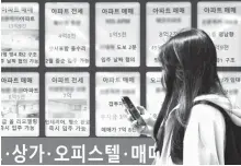  ?? Yonhap ?? A person walks by a real estate office’s bulletin board where sales and lease transactio­ns are posted in downtown Seoul, April 16.