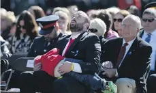  ?? THE CANADIAN PRESS ?? Brad Aschenbren­ner holds his son, Emmit, at a memorial service on Sunday in Ottawa. Aschenbren­ner’s wife, Sarah Beckett, was a Vancouver Island Mountie who died in a car crash while on duty.