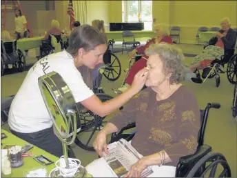  ??  ?? Maybelline Garnier employee Crystal Cathy blends foundation on the face of Memphis Jewish Home & Rehab resident Martha Barbee. Barbee received a complete makeover during L’Oréal’s Volunteer Day in June.