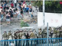  ?? (Mohamed Azakir/Reuters) ?? LEBANESE SOLDIERS take cover as they try and quell a protest on Thursday in Beirut after Lebanese Prime Minister Saad Hariri abandoned his effort to form a new government last week.