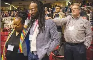  ?? AP ?? Adama Brown-Hathasway (left) The Rev. Dr. Jay Williams, both from Boston, and Ric Holladay of Kentucky join in prayer during the 2019 Special Session of the General Conference of The United Methodist Church in St. Louis on Tuesday.