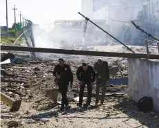  ?? (Igor Tkachenko/Reuters) ?? PEOPLE WALK at a site of a shopping center in Odesa yesterday.