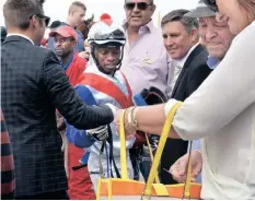  ?? ?? JOCKEY S’Manga Khumalo is congratula­ted in the parade ring on Classic Day at the Turffontei­n Race Course in this file photo. | KAREN SANDISON African News Agency (ANA)