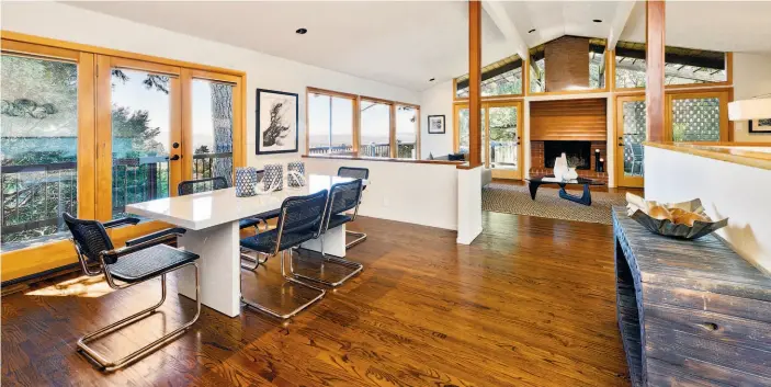  ?? Photos by Open Homes Photograph­y ?? Above: The living room-dining room at 6441 Castle Drive in Montclair includes a brick fireplace, support beams, a vaulted ceiling and large windows framing dramatic views. Below: The three-bedroom home has more than 2,800 square feet of living space.