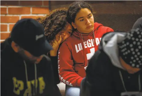  ?? Gabrielle Lurie / The Chronicle ?? Tammy Mendoza, 14 (right), rests her head on another student (who asked to be anonymous) during an exercise at Camp Everytown.