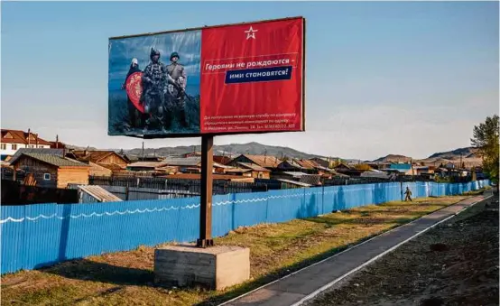  ?? NANNA HEITMANN/NEW YORK TIMES ?? A Russian military recruitmen­t billboard read, “Heroes are not born, they are made,” in Ulan-Ude, Russia, last May.