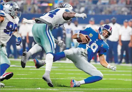  ?? MICHAEL AINSWORTH/AP PHOTO ?? Giants quarterbac­k Eli Manning (10) falls to the turf after taking a hit from Dallas linebacker Jaylon Smith during the second half of the Cowboys’ 20-13 victory on Sunday night in Arlington, Texas.