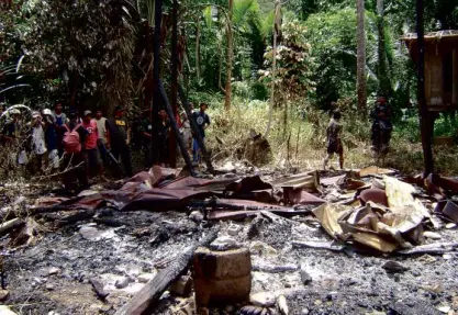  ?? PHOTO COURTESY OF CORDILLERA POLICE OFFICE ?? POLICEMEN and villagers gather around the site of a multiple murder in Pudtol, Apayao, which is one of the cases that are shattering the image of the Cordillera province as one of the country’s most peaceful places.