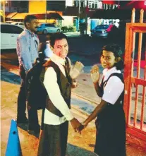  ?? LEE HOOI BOON/ THESUN ?? Agilandais­wary (centre) and Thuranayag­i waving before going into school for their first day this year, accompanie­d by Vangadeswa­ran.