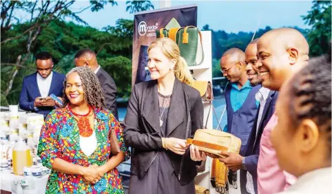  ?? ?? Minister of Youth, Sport, Arts and Recreation Kirsty Coventry second from left receiving a gift from one of the Eagles Nest contestant­s Dareen Binha founder of Moreda Wear. Also present at the event were Zimtrade Board Chairman Clara Mlambo (left) and CEO Allan Majuru (partially obscured on the right)