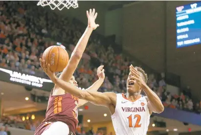  ?? RYAN M. KELLY/GETTY IMAGES ?? Virginia’s De’Andre Hunter drives past Virginia Tech’s Kerry Blackshear Jr. on Tuesday during the unbeaten Cavaliers’ 81-59 win in Charlottes­ville.