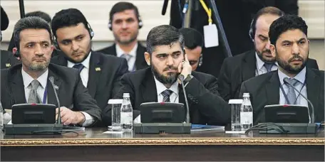  ?? Kirill Kudryavtse­v AFP/Getty Images ?? MOHAMMED ALLOUSH, center, a commander of the Islam Army, is a lead negotiator in the Syria talks in Astana, Kazakhstan.