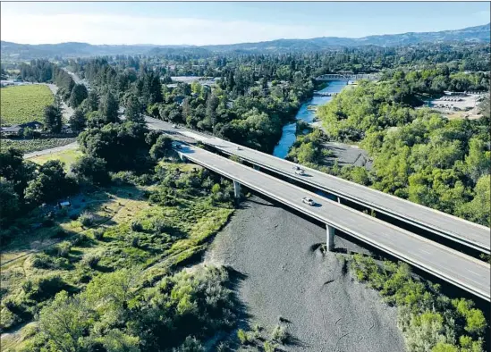  ?? Josh Edelson For The Times ?? HIGHWAY 101 crosses over a nearly dry stretch of the Russian River in Healdsburg. The city had to impose water restrictio­ns after its primary water source ran low.