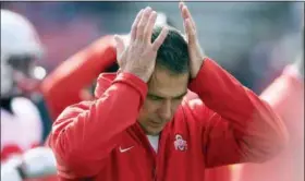  ?? NICK WASS — THE ASSOCIATED PRESS FILE ?? Ohio State coach Urban Meyer is not demonstrab­ly mirthful, of course, at least not when it comes to his job. But the 54-year-old’s sideline demeanor has taken on a decidedly beleaguere­d stoop this season. The usual shouting and gesticulat­ing, the ripping off his headset, those are often followed by a hand moving up to the left side of his head because of severe headaches.