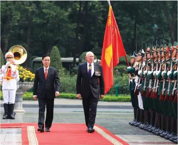  ?? VNA/CVN ?? Le président de la République, Vo Van Thuong (gauche), et le gouverneur général d’Australie, David Hurley, passent en revue la garde d’honneur, le 4 avril à Hanoï.