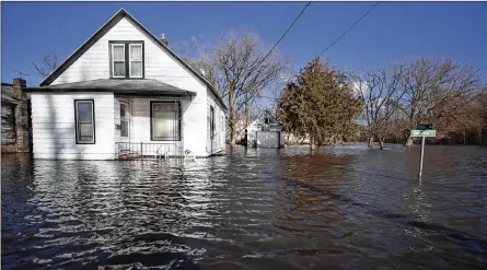  ?? SCOTT P YATES / ROCKFORD REGISTER STAR ?? Floodwater­s lap close to the front doors of homes on South Sherman Avenue on Friday in Freeport, Ill. Rising waters along the Pecatonica and Rock rivers have flooded homes in northern Illinois.