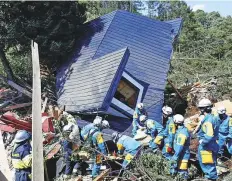  ?? Reuters ?? Rescue workers search for survivors from a house damaged by a landslide in Atsuma town, Hokkaido, yesterday.