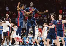  ?? Jamie Squire/getty Images ?? Duquesne’s Kareem Rozier, left, and Fousseyni Drame celebrate during their upset of BYU on Thursday in Omaha, Neb.