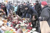  ?? - Reuters ?? TRAGEDY: People place toys and flowers at a makeshift memorial for the victims of a shopping mall fire in the Siberian city of Kemerovo, Russia on March 26, 2018.