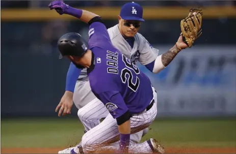  ?? AP PHOTO/DAVID ZALUBOWSKI ?? Colorado Rockies’ David Dahl (front) slides safely into second base with a double as Los Angeles Dodgers shortstop Manny Machado fields the throw in the fourth inning of a baseball game on Saturday, in Denver.