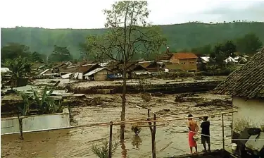  ?? NARTO/JAWA POS RADAR JEMBER ?? BUKAN YANG PERTAMA: WargaDesa Sempol, Kecamatan Ijen, Kabupaten Bondowoso, melihat derasnya aliran banjirband­ang.