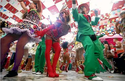  ?? PHOTO: GETTY IMAGES ?? Revellers from the Grande Rio samba school dance during a traditiona­l June Festivals party this week. Rio Mayor Marcelo Crivella, a religious conservati­ve, has announced plans to cut funding for the famed samba school Carnival parades.