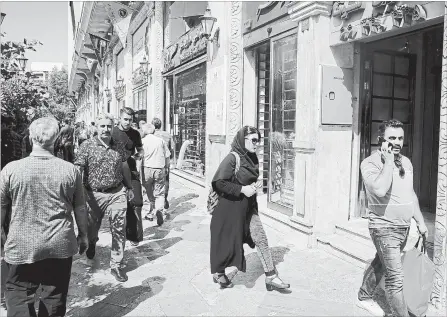  ?? EBRAHIM NOROOZI THE ASSOCIATED PRESS ?? People walk in front of a currency exchange shop in downtown Tehran, Iran, Wednesday, Sept. 5, 2018.