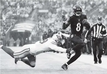  ?? PATRICK SMITH Getty Images ?? Ravens quarterbac­k Lamar Jackson is forced out of bounds by the 49ers’ DeForest Buckner in the second quarter. Jackson became the first quarterbac­k in NFL history to have four 100-yard rushing games in a season.