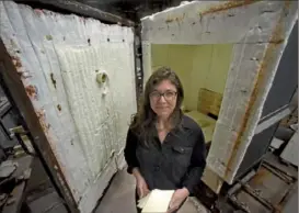  ??  ?? Top: Ms. Johnson holds some of her tiles in front of the pottery kiln in the ceramics studio at Braddock's Carnegie Library.