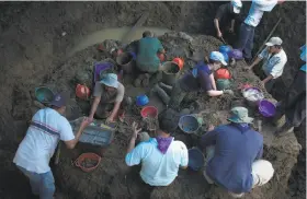  ?? Photos by Victor J Blue / New York Times ?? Anthropolo­gists of the Guatemalan Forensic Anthropolo­gy Foundation exhume a mass grave of victims in the state of Quiche Guatemala in 2005.