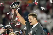  ?? LYNNE SLADKY — THE ASSOCIATED PRESS ?? Tampa Bay Buccaneers quarterbac­k Tom Brady celebrates with the Vince Lombardi Trophy after the Super Bowl 55 win over the Chiefs Sunday night in Tampa.
