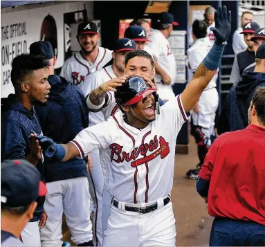  ?? CURTIS COMPTON / CCOMPTON@AJC.COM ?? Following his stunning doublehead­er performanc­e Monday, leading off both games with home runs, rookie Ronald Acuna does it again Tuesday, getting high- fives after hitting his third leadoff homer in a row.