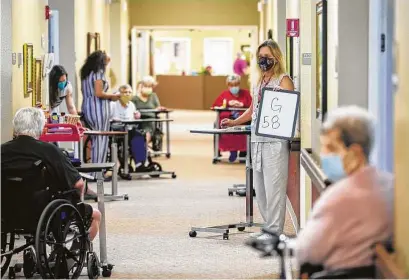  ?? Godofredo A. Vásquez / Staff photograph­er ?? Angie Galloway calls out numbers as residents play a socially distanced game of bingo at the Bayou Pines Care Center.