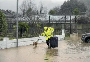  ?? BRADEN FASTIER/STUFF ?? A resident evacuates their home in Nile St, Nelson last week. The city’s housing crisis is set to get worse, with floods and slips seeing dozens of homes condemned and damaged.