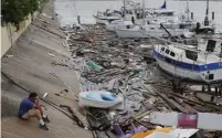  ?? AP ?? SURGING SEAS: A boat owner surveys the damage on Sunday after Hurricane Hanna slammed the coast of South Texas.