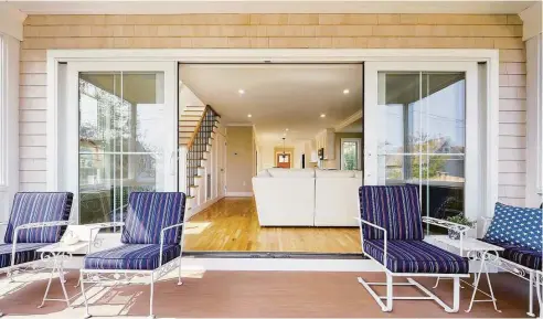  ?? Dennis M. Carbo Photograph­y/ Contribute­d photos ?? Above, The screened-in porch doesn't technicall­y count toward the house's living area, but it's an expansive and welcome aspect in the summer (and beyond). With such a long area, the homeowners could space things out a bit. “Everybody stacks the TV and fireplace,” Greg Raucci says. “I loved the look of side-by-side. Nobody ever does it that way.”