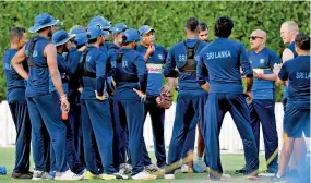  ??  ?? Sri Lanka Coach Chandika Hathurusin­gha in conversati­on with team-members during a training session