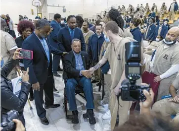  ?? SHANNA MADISON/CHICAGO TRIBUNE PHOTOS ?? The Rev. Jesse Jackson shakes hands with inmates at the Cook County Department of Correction­s on Saturday in Chicago.
