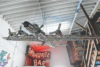  ??  ?? A beer-can bomber from the shuttered Hangar Bar hangs from a ceiling in Lakewood.