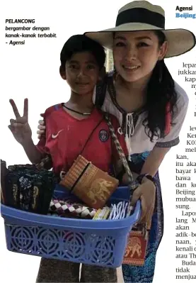  ??  ?? PELANCONG bergambar dengan kanak-kanak terbabit. - Agensi