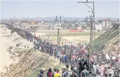  ?? AFP ?? Displaced Palestinia­ns take the coastal Rashid road to return to Gaza City as they pass through Nuseirat in the central Gaza Strip on Sunday.