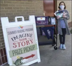  ?? The Sentinel-Record/Grace Brown ?? ‘IMAGINE YOUR STORY’: Kasey McKinney, assistant children’s librarian at the Garland County Library, holds up prizes given out for the summer reading program on Wednesday.